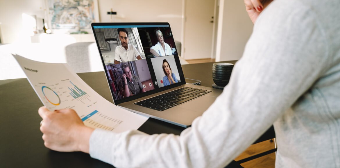 Business team in video conference Group of businessmen and businesswomen smart working from home. View from side of woman talking to her colleagues about business plan over a video conference.
